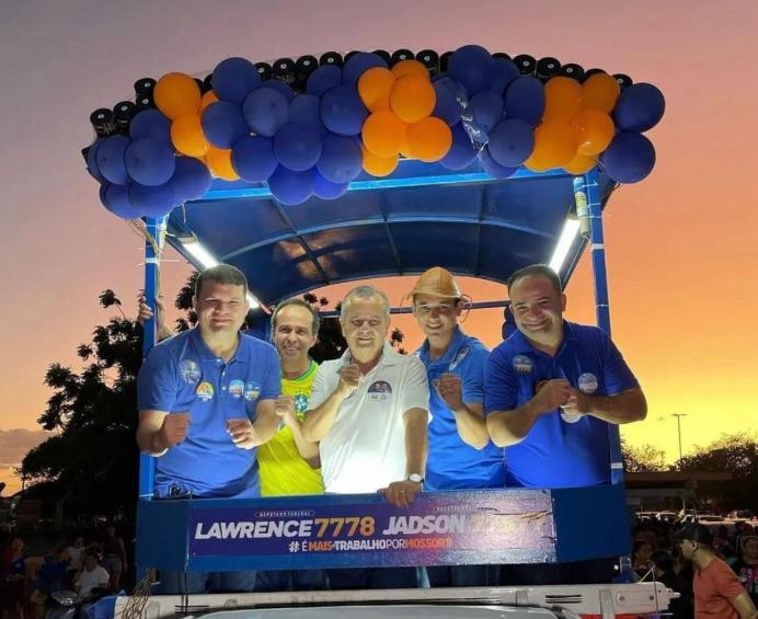 Ato político com apoiadores em um carro de som ao entardecer